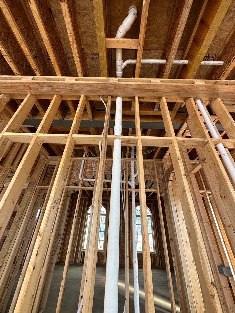A new drain stack running up through the framing of a new home