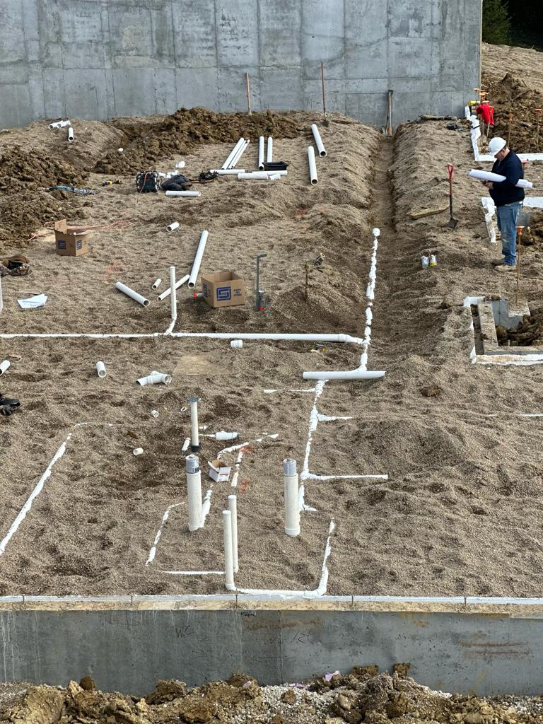 The Mendez Plumbing crew roughing in underground plumbing inside new foundation walls